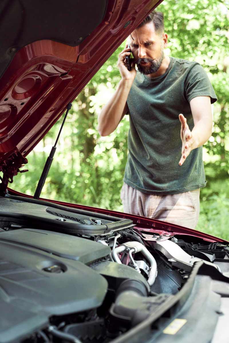 Junger Mann prüft Getriebeschaden bei Schrottauto Ankauf Köln